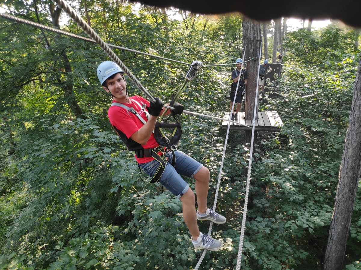 One Cloudflighter climbing a rope in the tree crowns during a Funtastic event