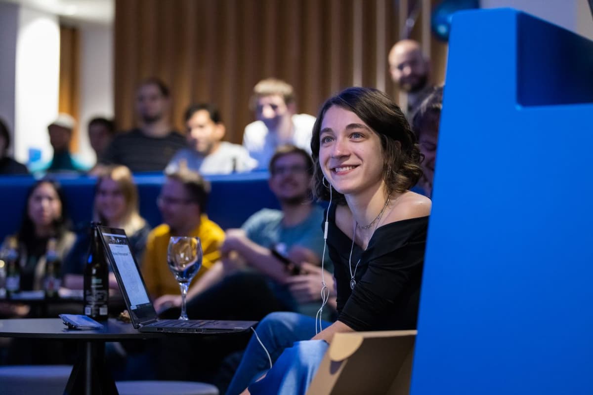 Smiling Cloudflighter sitting on the edge of the big C in the Viennese office